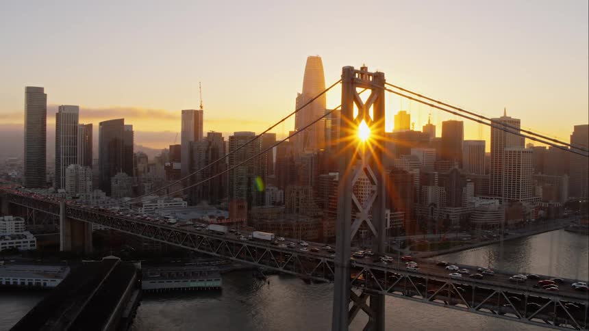 Vehicles travel along a bridge to a large city
