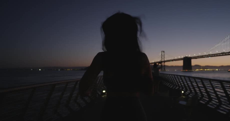 A woman running on a pier in the dark