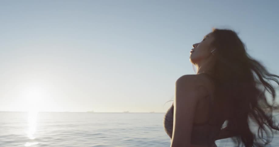 Young woman stretching near the shoreline at the beach