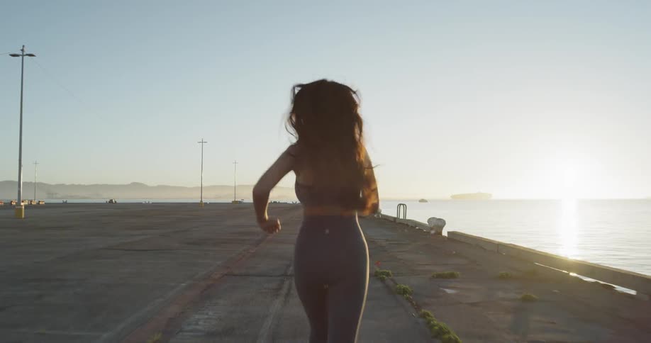 A woman runs on the open sidewalk