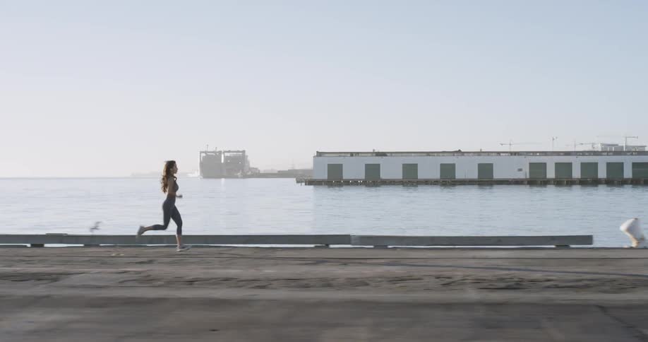 Woman jogging along water