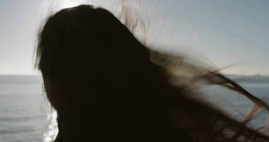A woman running next to the ocean on a sunny day