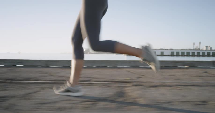 Woman jogging on the dock by the sea