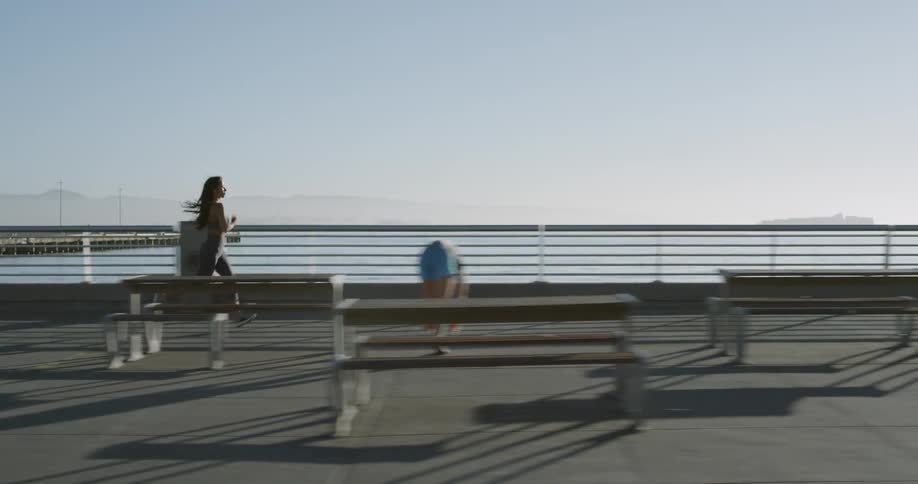 A young woman runs along a boardwalk