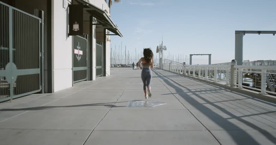 A woman running along a boardwalk