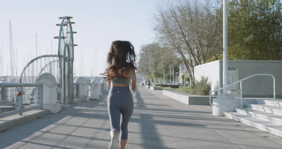 A young woman jogs along a boardwalk