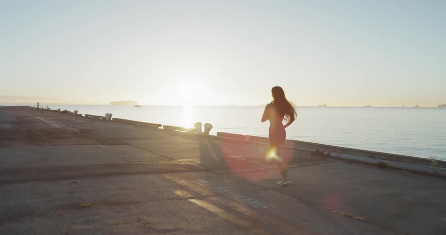 Athletic woman is running along an embankment