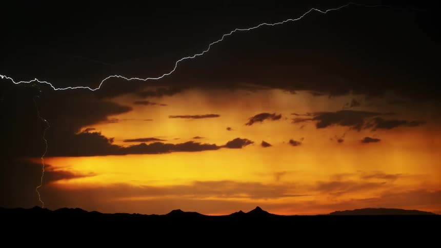 Lightning streaks sky and hits ground at sunset