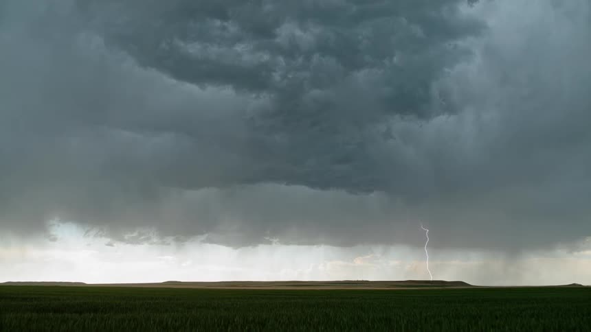 Dark and heavy looking rain clouds move across a prairie