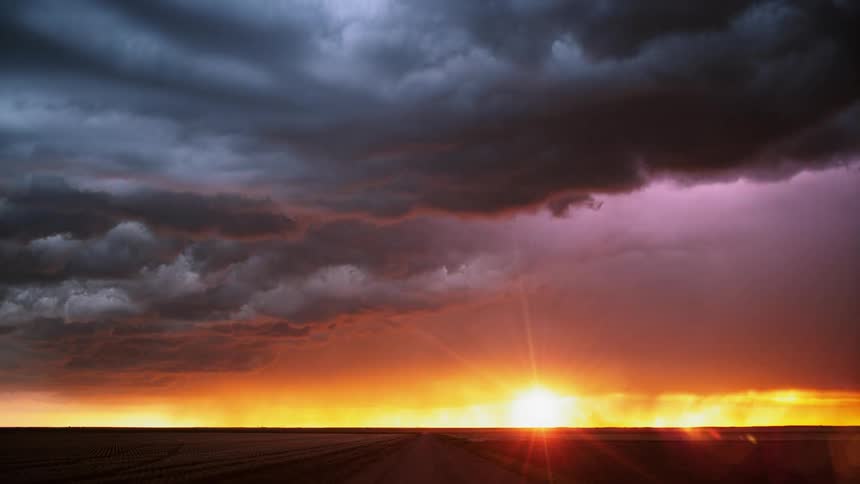 Thunder and lightning streaking through clouds during sunset