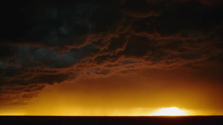 Storm clouds with flashing lightning hover in a dark sky