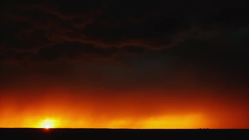 Lightning that is flashing in the distance over a field