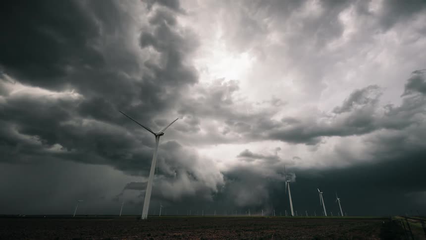 Storm clouds swirl over wind turbines