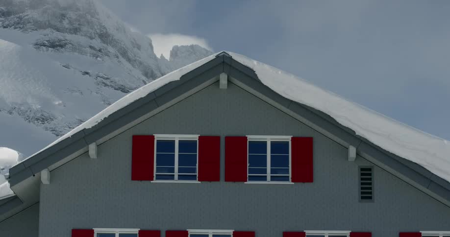 A snow covered roof in front of a mountain