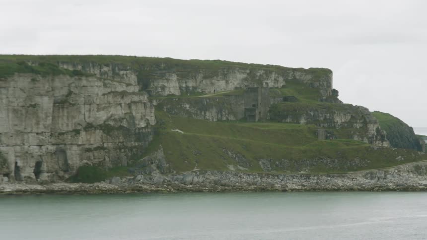 A flat topped headline surrounded by sea on a cloudy day