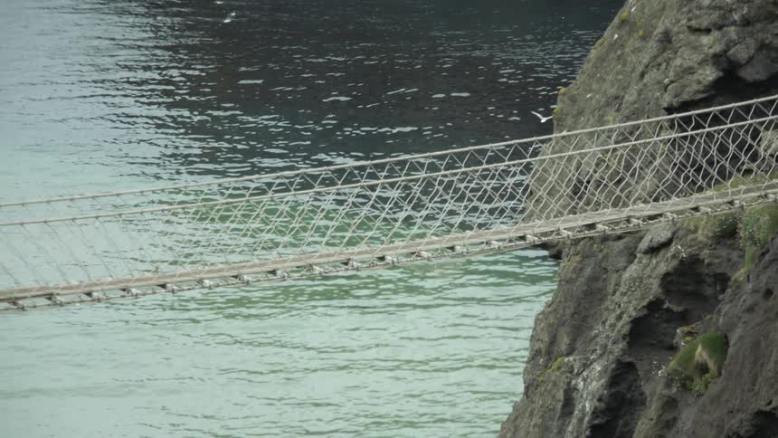 Two women walk across a foot bridge