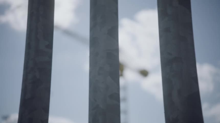 A construction crane behind a fence