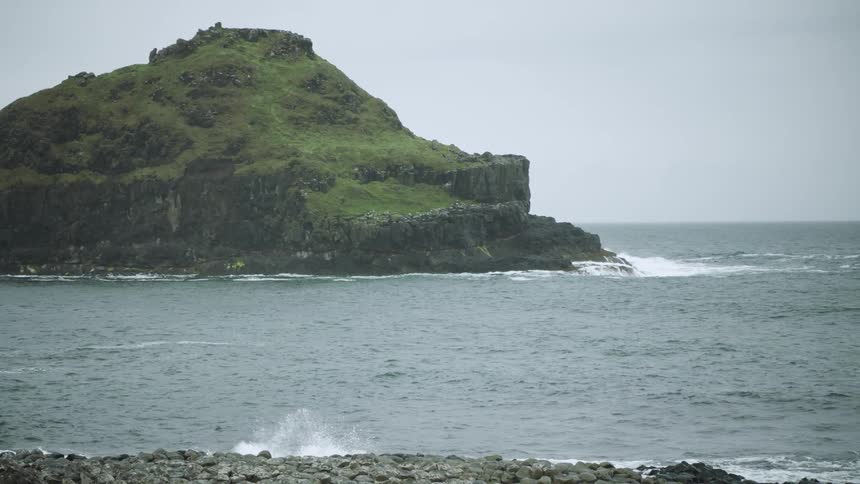 Island in ocean off rocky beach