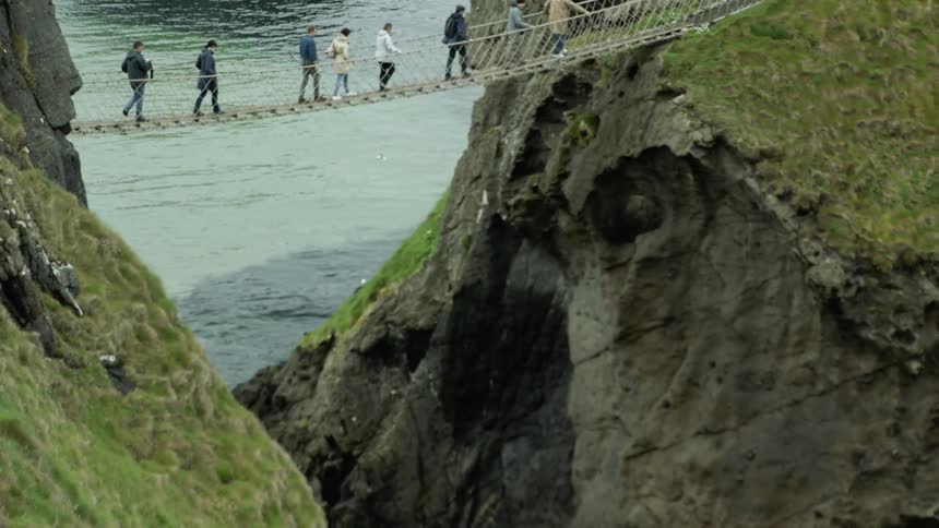 People walk across a rope bridge