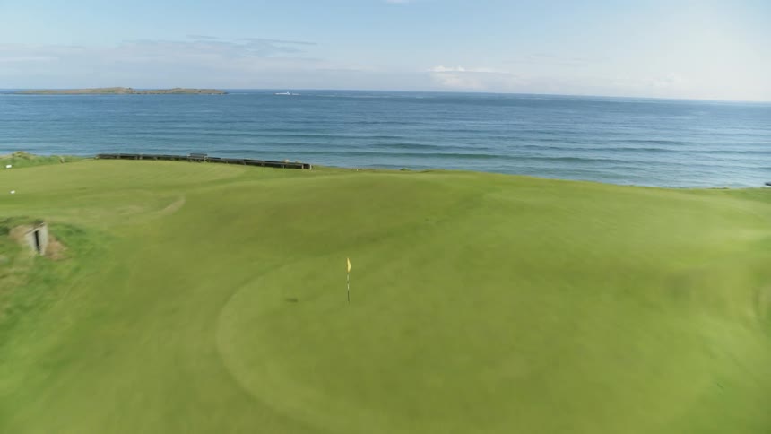 Camera is moving rapidly backwards cross the ocean and then the golf course