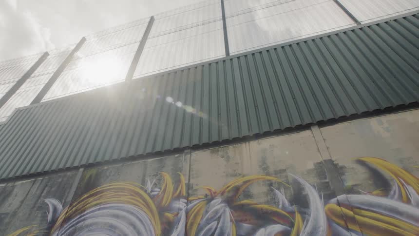 A multi tiered fence with the lower portion painted with a mural