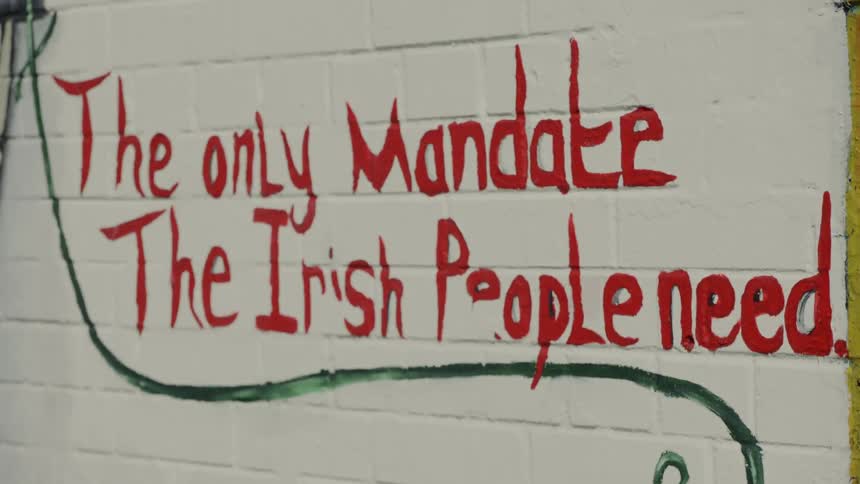 A red lettered sign is painted on white bricks