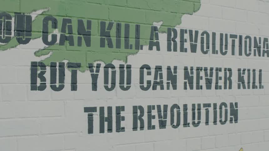 Quote in black font painted onto a brick wall