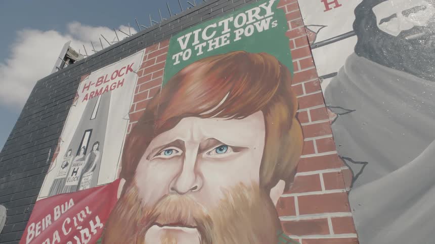 A nationalist mural in ulster depicts a man with a red beard and political statements