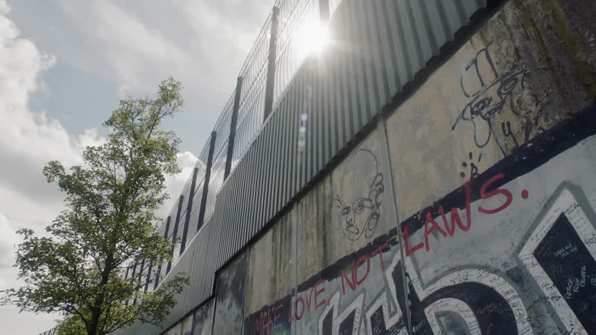 Graffiti on wall of fence topped structure
