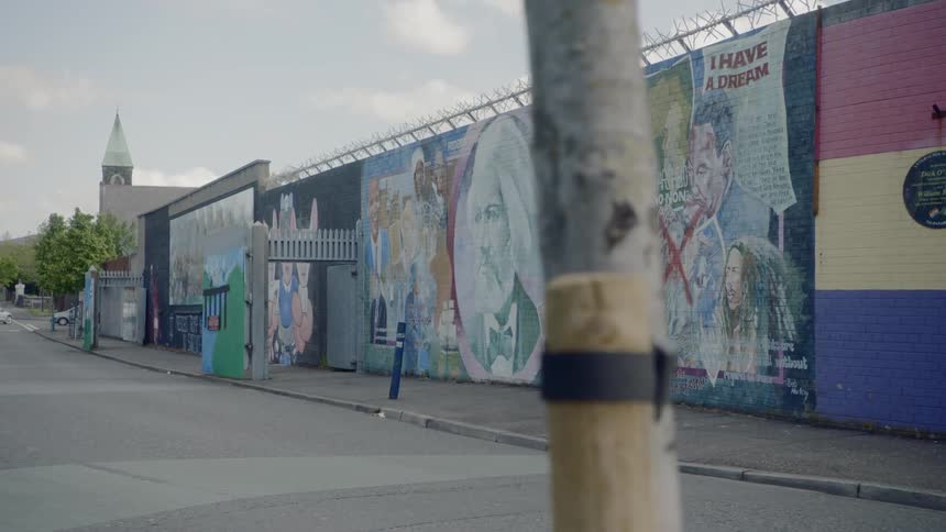 A wall mural on the side of a building in a neighborhood