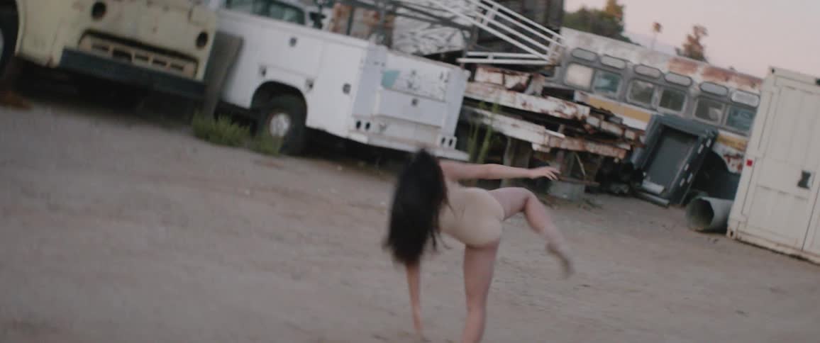 Woman wearing leotard dance in parking lot outdoors