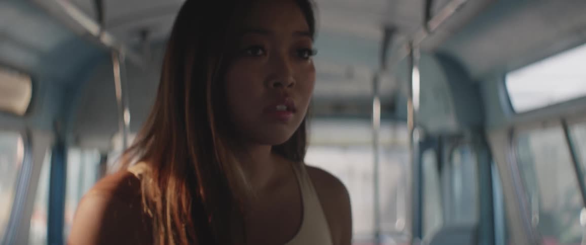 Woman with long hair looking around inside of a bus