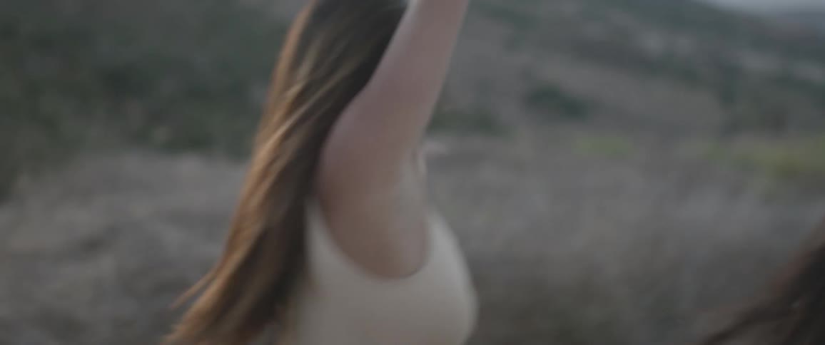 Two young woman dance in a remote outdoor place