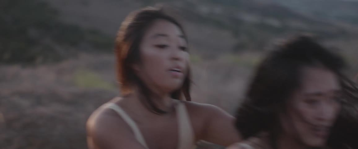 Two asian women dance together outdoors