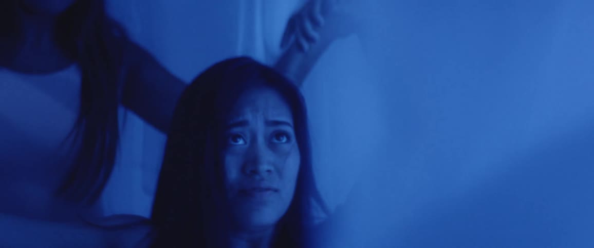 Under the transparent curtains asian women dance in the blue illuminated room
