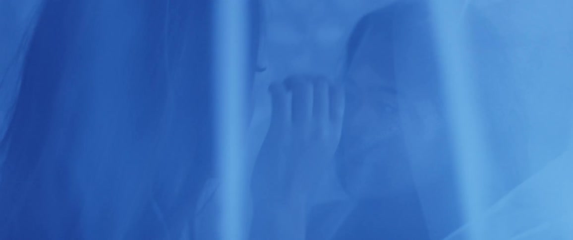 Two women standing face to face while one strokes the other ones hair