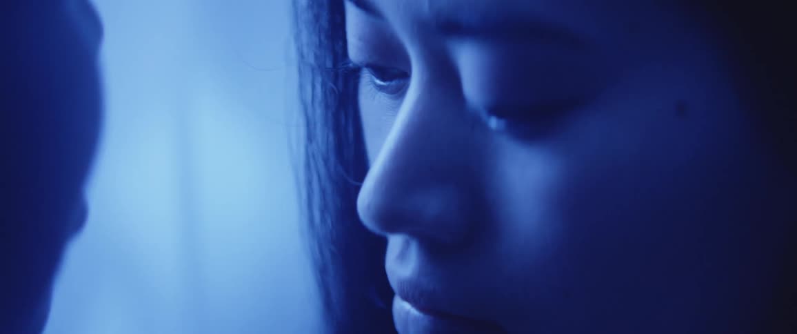 An asian woman looks into another persons face