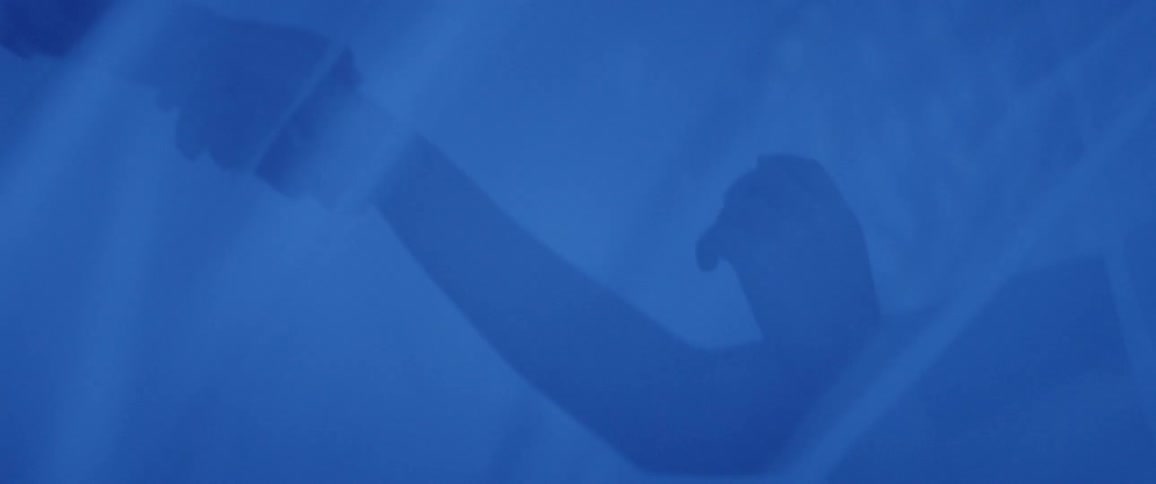 Two women dance together in a tent of veils and electric blue light