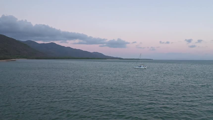 A time lapse view of a ship off of the coast on calm open waters on a nice day