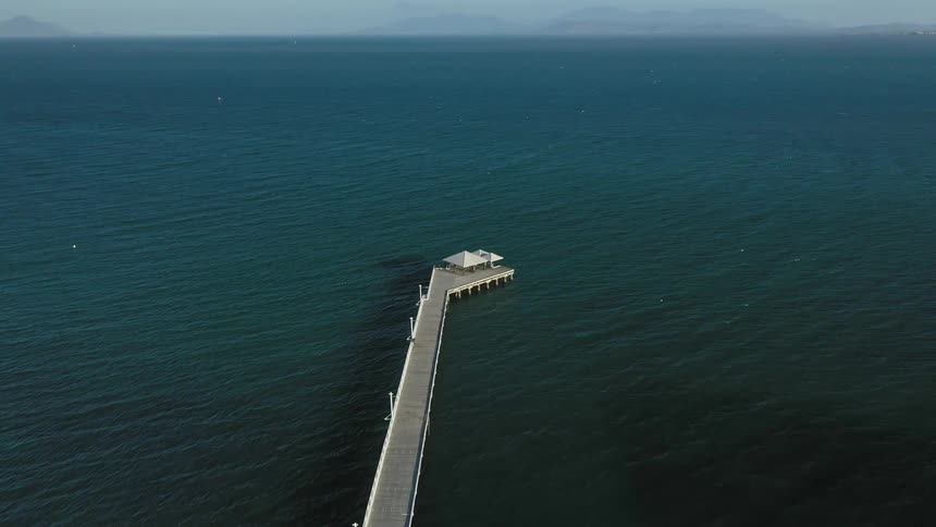 A pier leading out to a shelter extends out into open water
