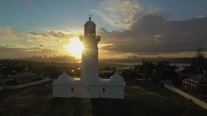 A lighthouse sits on the edge of a small town