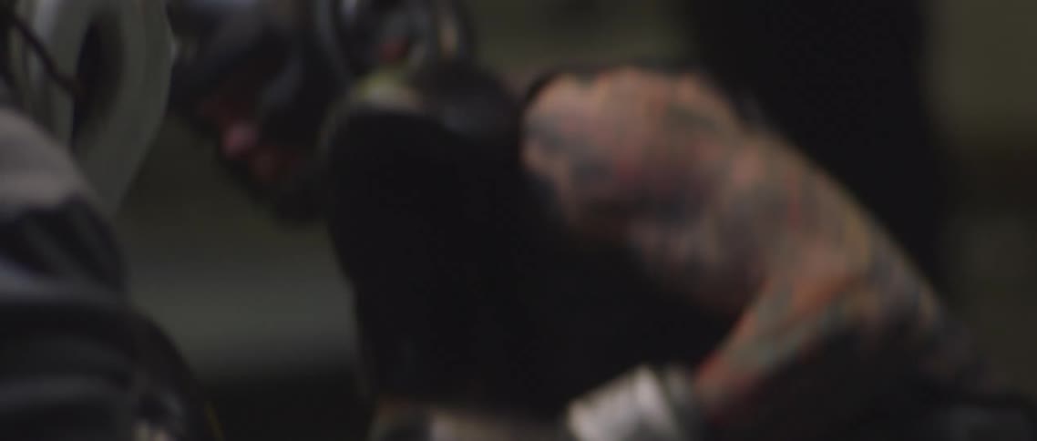 Two boxers wearing protection headgears train in boxing gym