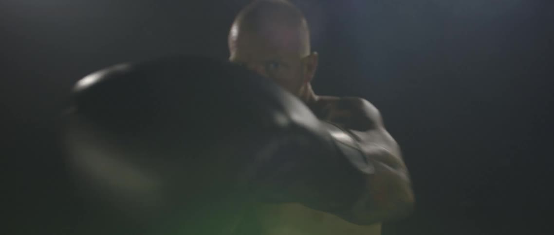 Male boxer jabbing and punching against a black background