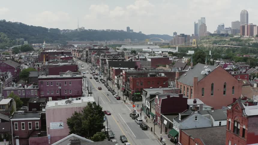 A view from above of an older town outside of a large city on a nice day