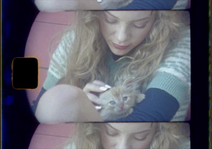 A blonde white woman pets a kitten