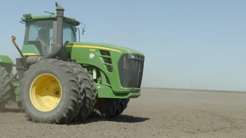 A farmer drives a tractor over a field