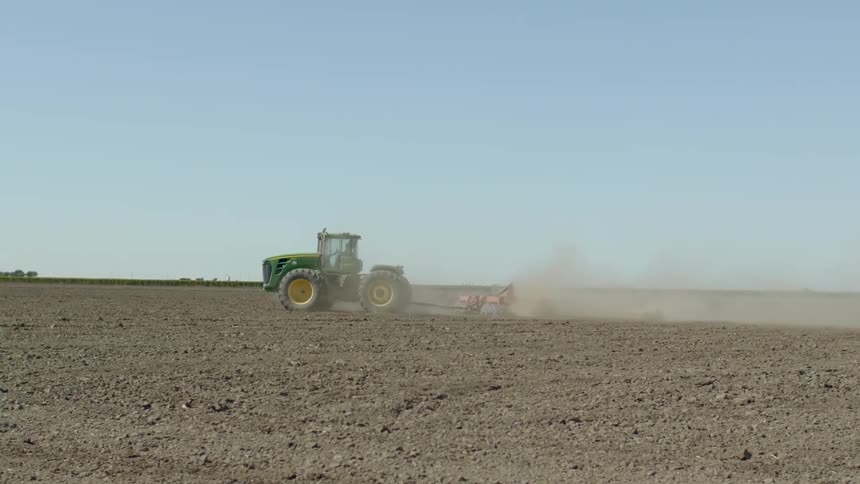 A tractor plows a fallow field