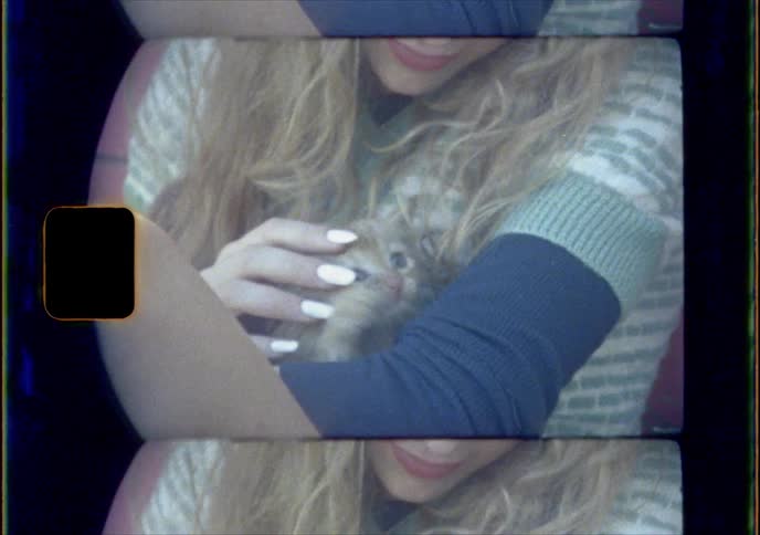 A woman holds and plays with a small kitten