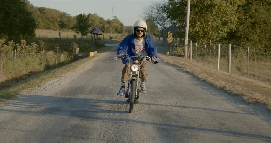 Man riding an old motorcycle on a country road in the countryside