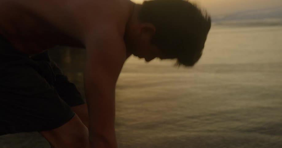 A manstretches next to the ocean